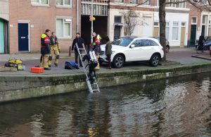 Duikers van de brandweer halen laptop uit water Boomsluiterskade Den Haag