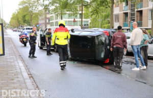 Personenauto op zijn kant na ongeval met bedrijfsbusje Erasmusweg Den Haag