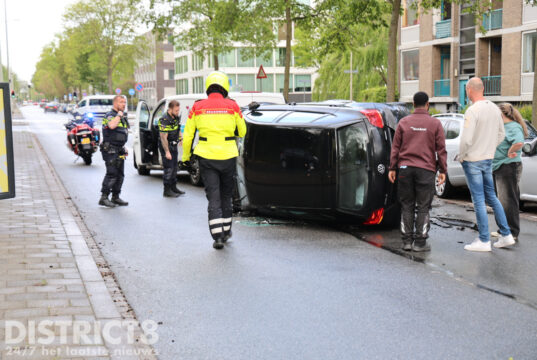 Personenauto op zijn kant na ongeval met bedrijfsbusje Erasmusweg Den Haag