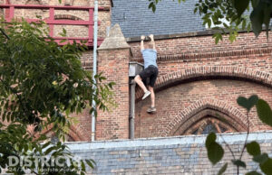 Dronken man klimt via regenpijp het dak op van de Oude Kerk Heilige Geestkerkhof Delft