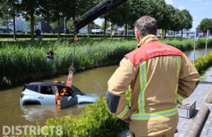 Auto te water, bestuurster veilig op de kant Donau Den Haag