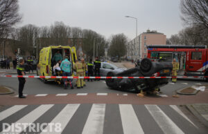 Auto over de kop na aanrijding Erasmusweg Den Haag