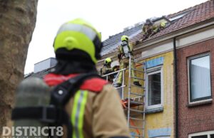 Omstanders blussen met tuinslang beginnende dakbrand Sint Olofsstraat Delft