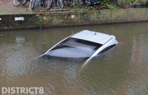 Bitter einde aan de vakantie; auto rijdt de gracht in Buitenwatersloot Delft