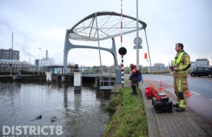Brandweerduikers zoeken naar te water geraakt iPhone in de Delftsche Vliet Delft