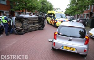 Auto op zijn kant na ongeval Vreeswijkstraat Den Haag