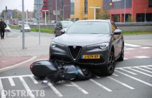 Snorscooter vast onder auto na aanrijding Waldorpstraat Den Haag