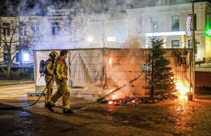 Kerstbomen en spandoek in brand op Prins Hendrikplein Den Haag