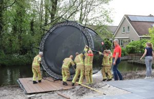 Brandweer haalt te water geraakte trampoline uit water Wilgenlaan Schipluiden