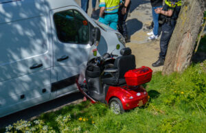 Man op scootmobiel rijdt dijk af langs Laan 1940-1945 Maassluis