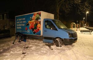 Bezorger van supermarkt Albert Heijn met zijn bus vast in de sneeuw Kiekendiefhof Delft