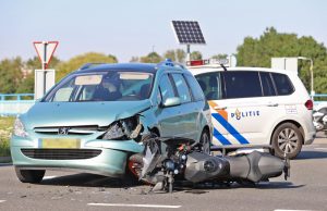 Brandweermannen assisteren na ongeval tussen motorrijder en auto Rijksstraatweg Schipluiden