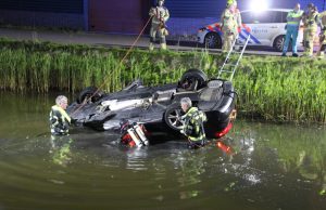 Auto over de kop te water aan het Honderdland in Maasdijk