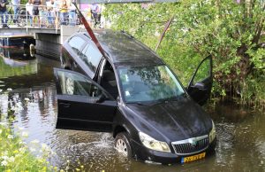 Oeps! Auto rolt van oprit af en belandt in sloot Strijpkade Den Haag