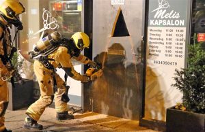 Middelbrand in kapsalon; Brandweer zaagt deur open Melis Stokelaan Den Haag