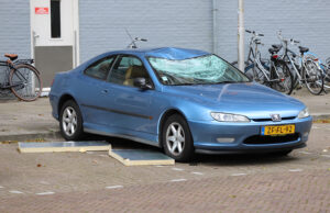 Geparkeerde auto zwaar beschadigd door vallende platen César Franckstraat Delft