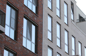 Brandweer verwijdert loszittende regenpijp onderdelen Nieuwe Gracht Delft