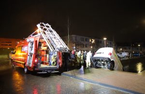Busje van bezorgdienst belandt deels in gracht Graaf Floriskade Delft