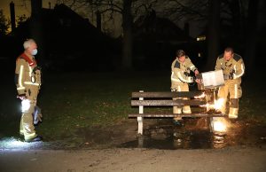 Brandweer blust in brand gestoken bankje in park Arentsburgh Voorburg