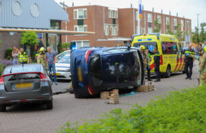 Auto op zijn kant na aanrijding Lijsterlaan Maassluis
