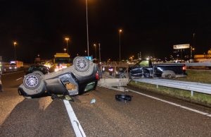 Auto op de kop, andere bovenop vangrail na aanrijding A4 Pernis