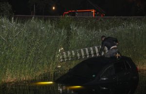 Bestuurder klimt op dak van te water geraakte auto Drevenpark Vlaardingen
