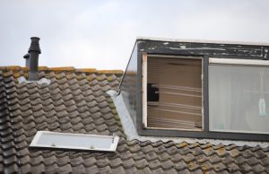 Brandweer haalt los gewaaid raam van dak af Van der Kamlaan Delft