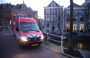 Brandweerduiker zoekt naar gevallen mobiel in Delftse gracht Koornmarkt Delft