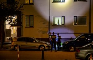 Kogelgaten in het raam na beschieting woning Van Harmelenstraat Rotterdam