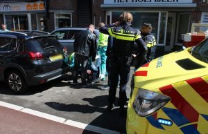 Opzittenden van scooter klappen achterop auto Badhuisstraat Den Haag